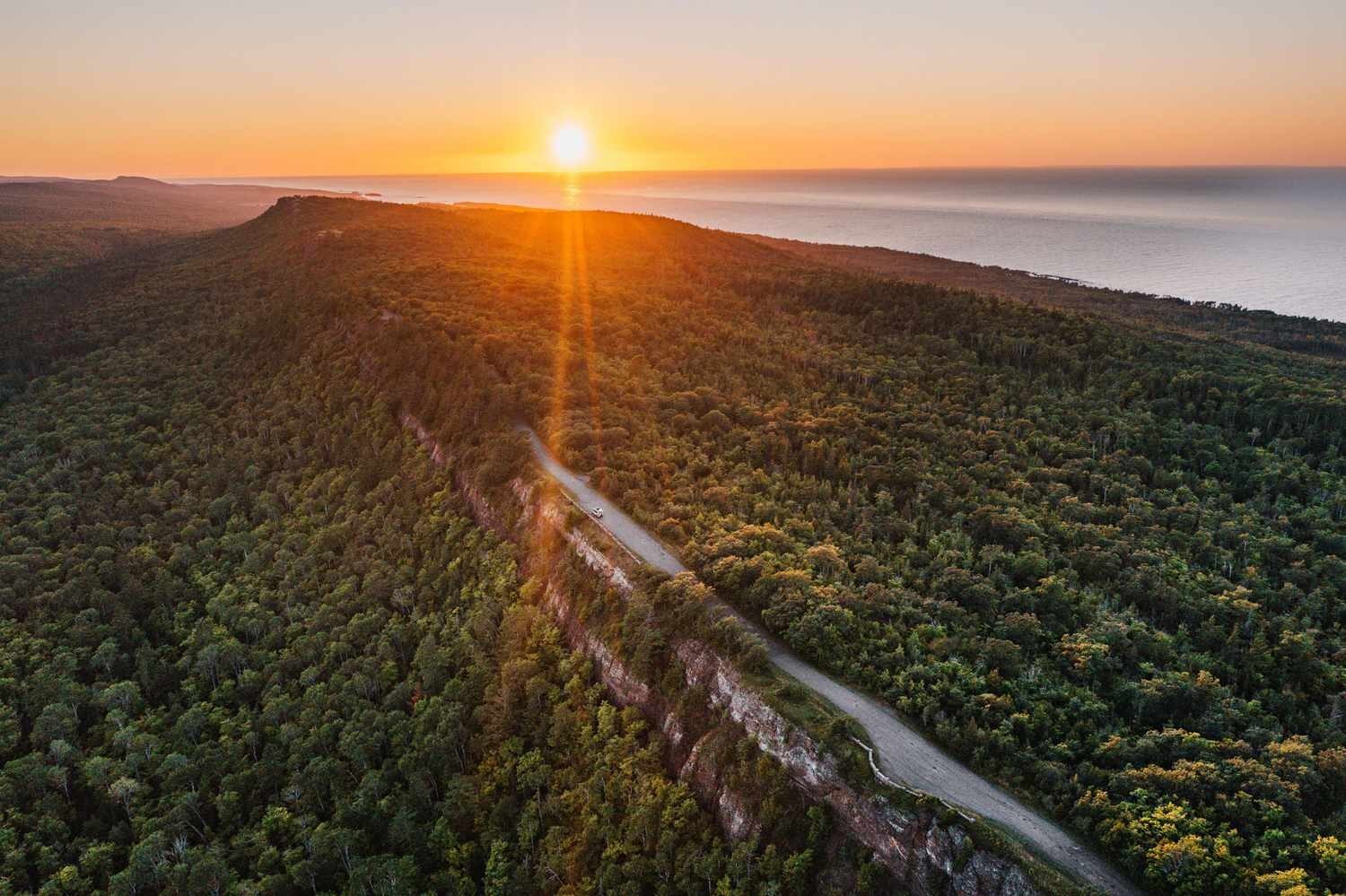 Aerial view of forested Keweenaw Peninsula along Lake Superior at sunset